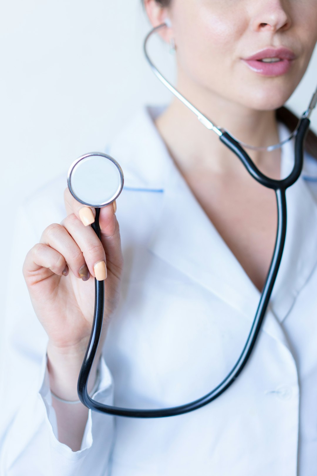 a-woman-in-a-white-shirt-holding-a-stethoscope-te7-jvk-yu