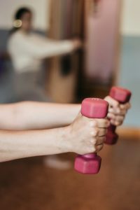 person-holding-pink-and-white-dumbbells-lb6lbkbe1xa